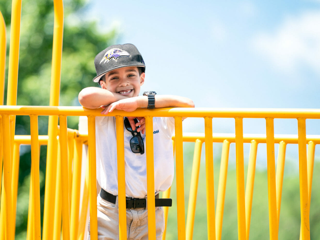 Smiling boy stands on bridge of playground