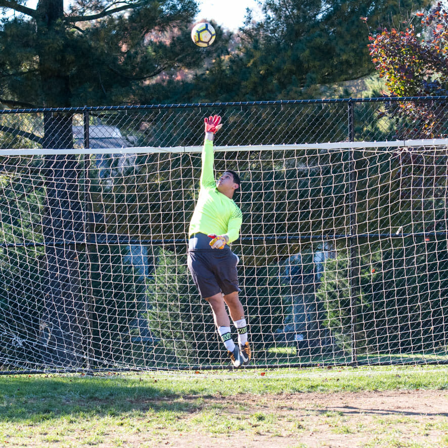 Goalie jumps for soccer ball