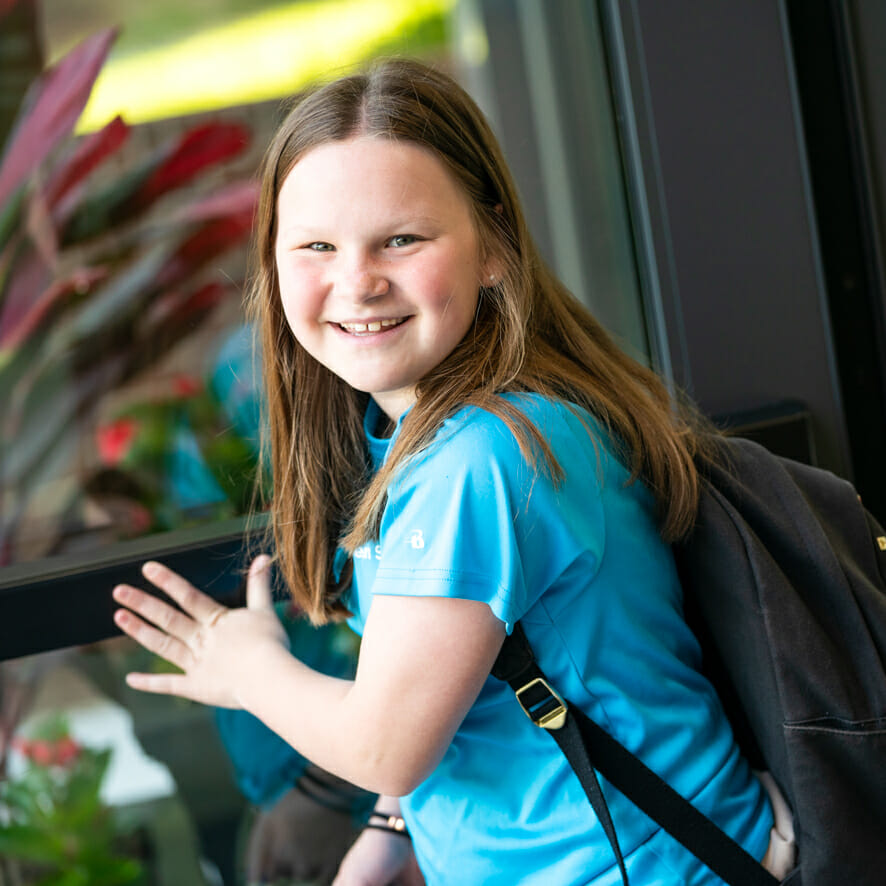 Girl with backpack pushes open door