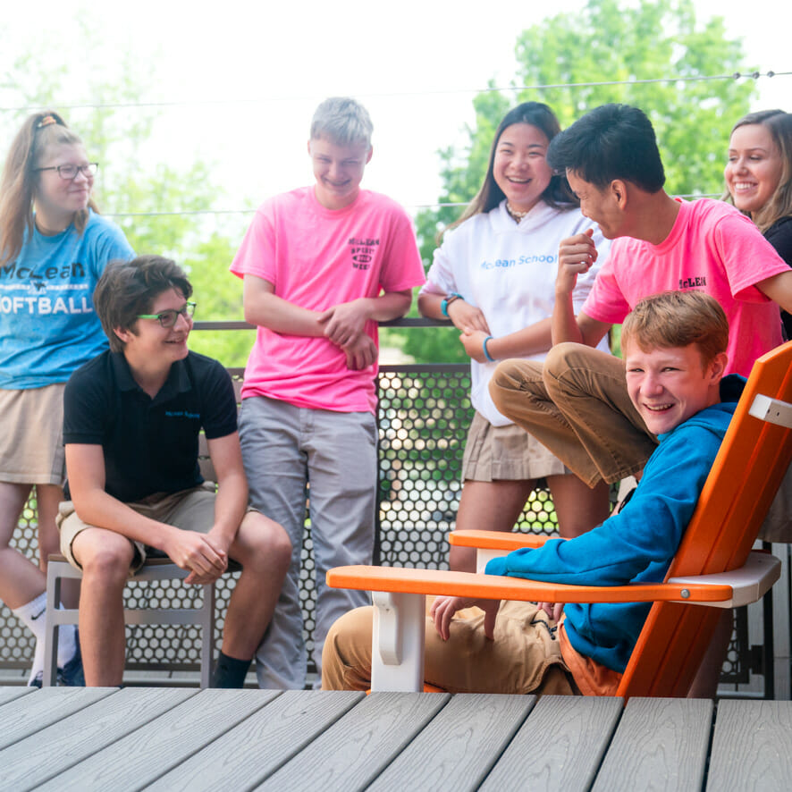 Upper school students laugh together on porch