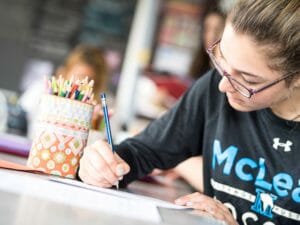 Upper school student writes in notebook