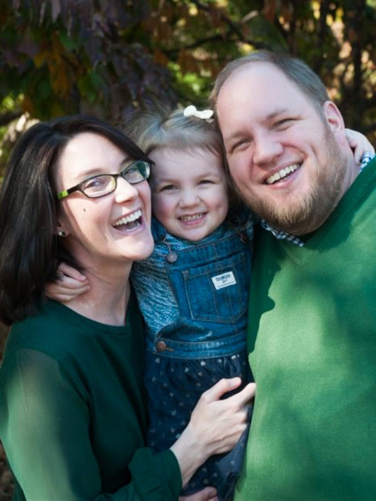 Kristen Murphy, Middle School Literature Teacher, smiles at camera with her family